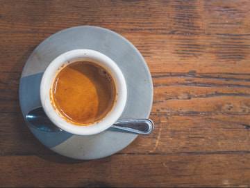 A fresh cup of espresso sitting on a table.